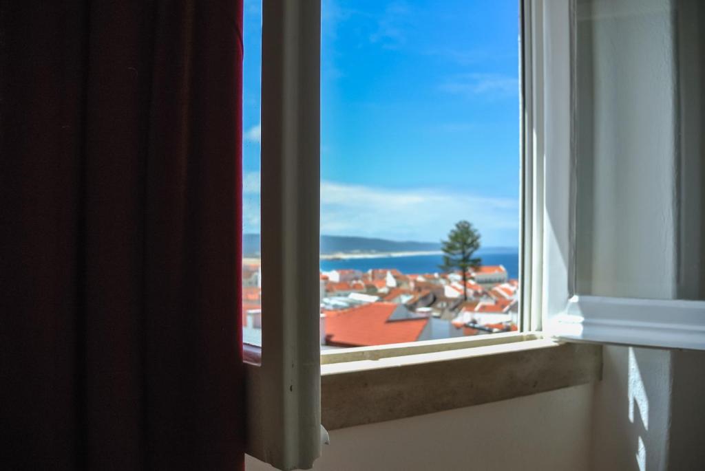 纳扎雷Nazaré Hostel - Rooms & Dorms的享有城市美景的开放式窗户。