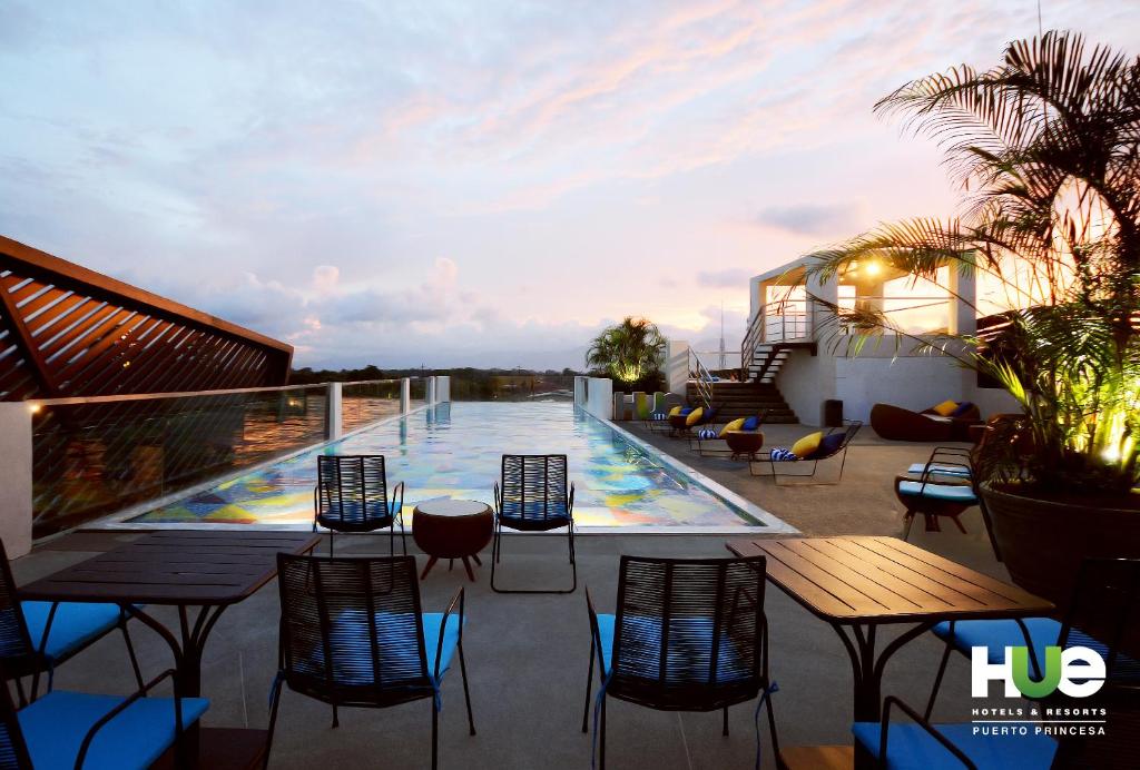 公主港HII普林塞萨港顺化度假酒店 的一个带桌椅的阳台和一个游泳池