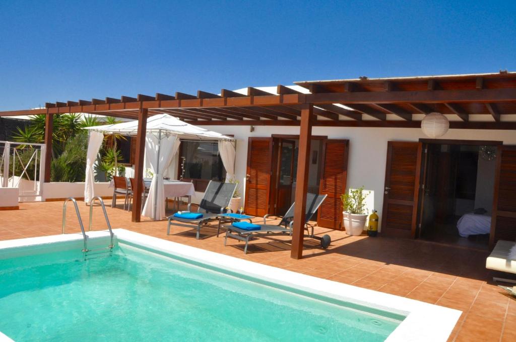 普拉亚布兰卡Happy Villa con piscina privada的一个带游泳池和凉亭的房子