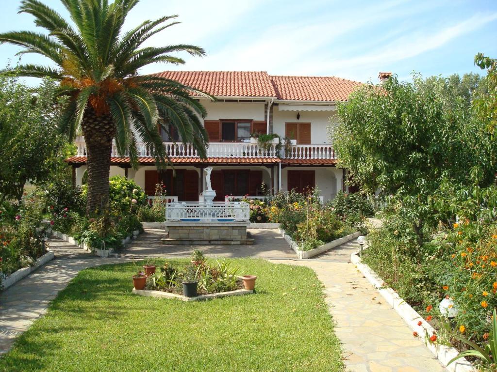 萨尔蒂Villa Tonia Apartments的棕榈树和花园的房子