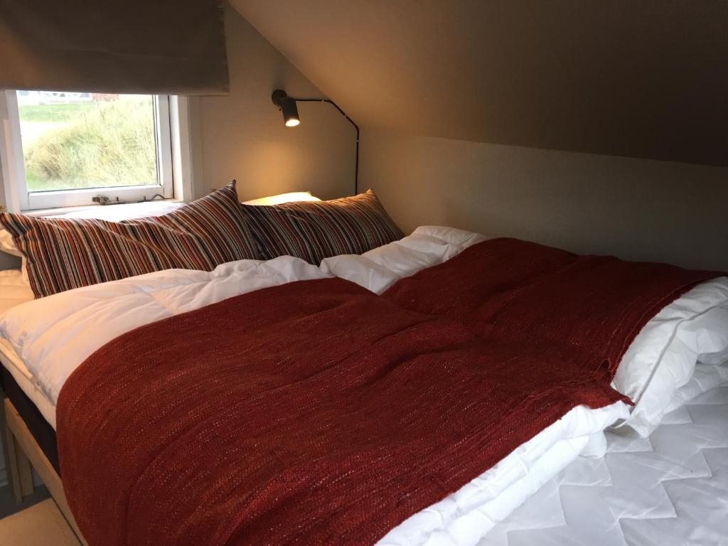 维泽桑讷Dancamps Nordsø Water Park的卧室里一张床上的红色毯子