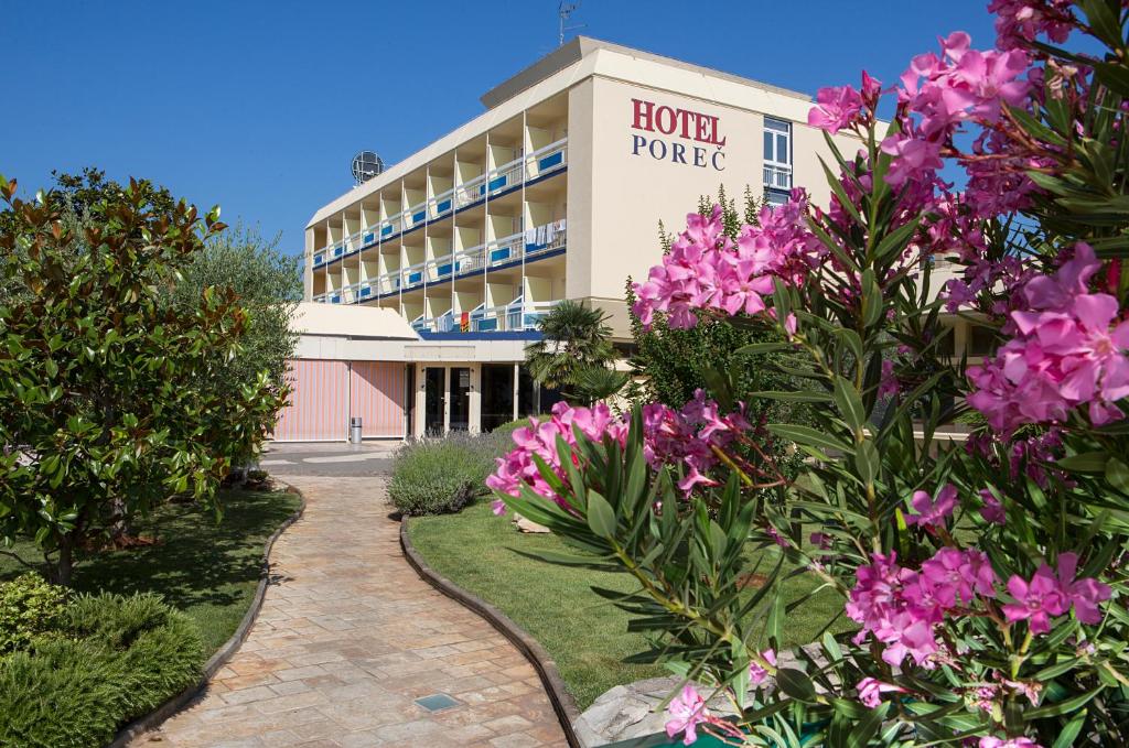 波雷奇波雷奇酒店的一座建筑前有粉红色花卉的酒店