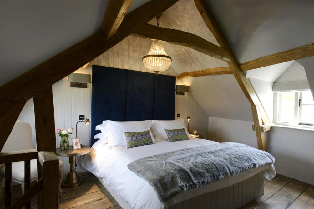莫顿因马什沃尔纳特度假屋的一间卧室配有一张大床和蓝色床头板