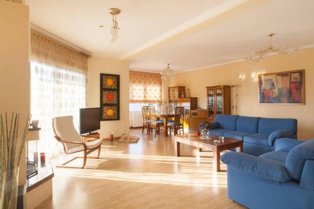 拉格尼西House,1000m from beach的客厅配有蓝色的沙发和桌子