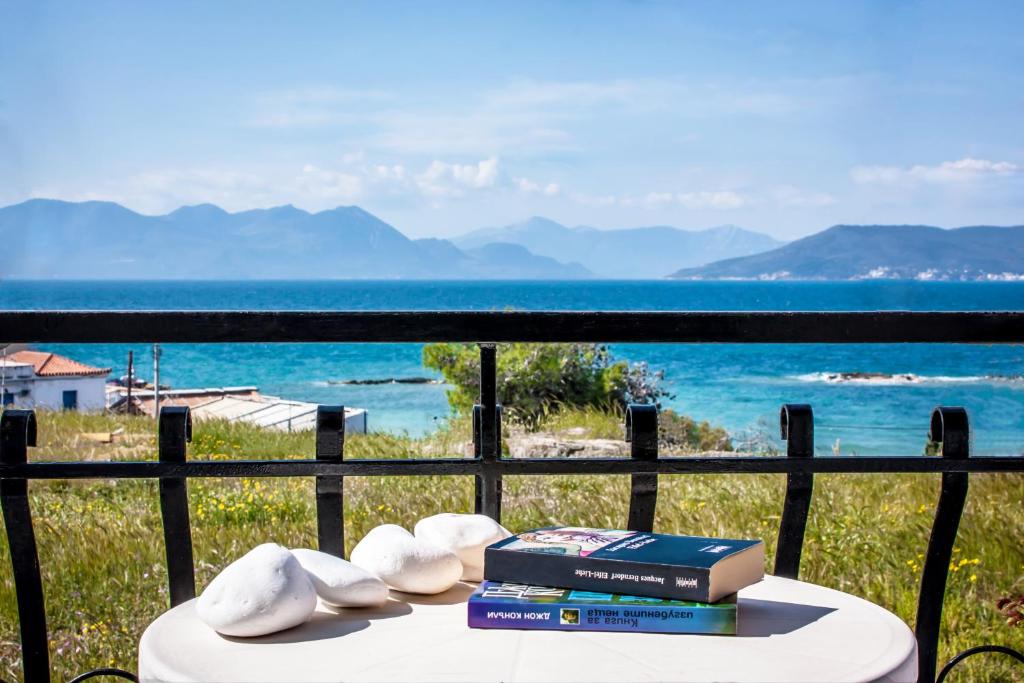 爱琴娜岛乌尔丽卡酒店的一张桌子,配有书籍,享有海景