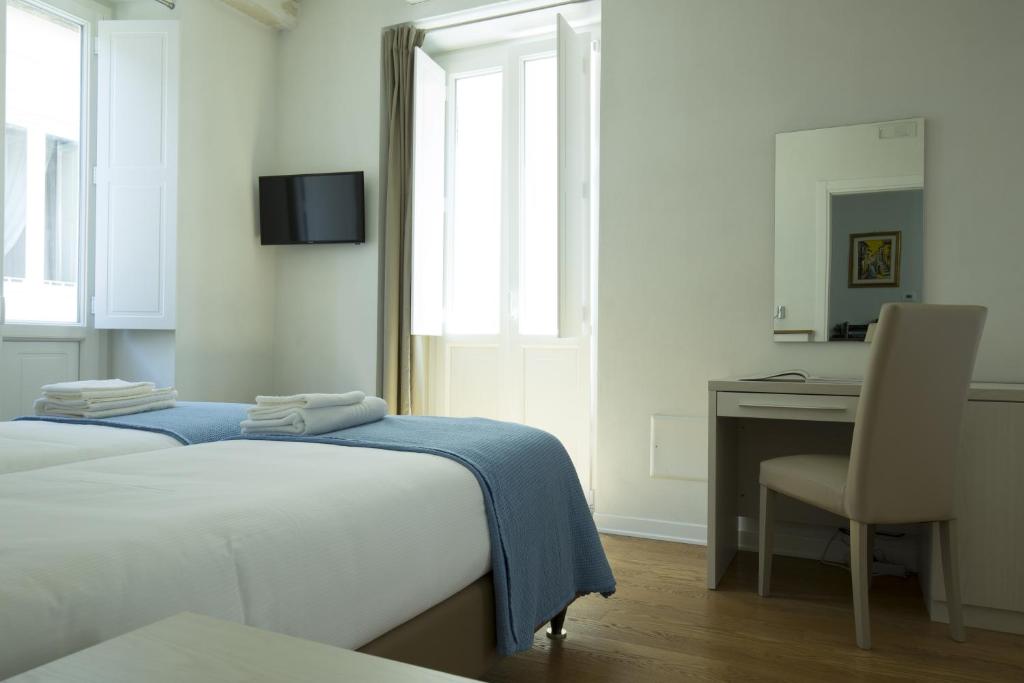 维博瓦伦蒂亚B&B Cerasarella的一间卧室配有一张床、一张桌子和一把椅子