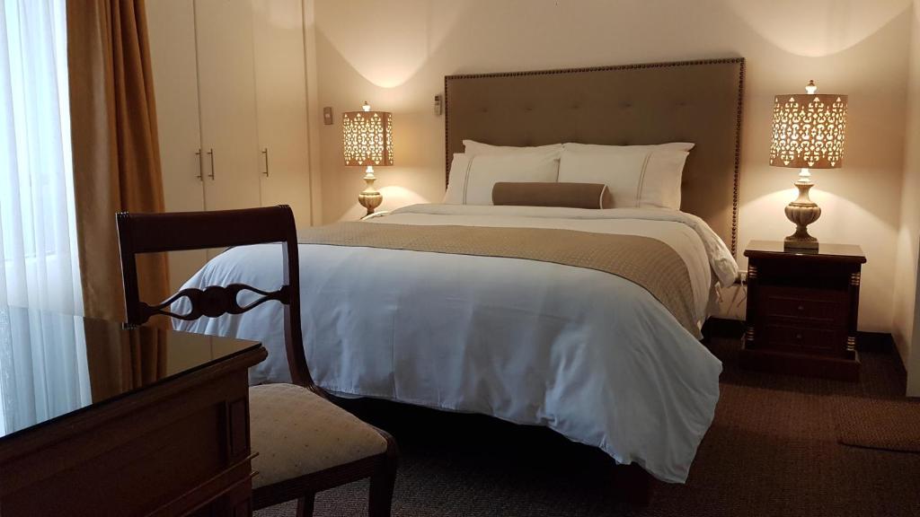 利马圣马丁公寓酒店的一间卧室配有一张大床和两盏灯。