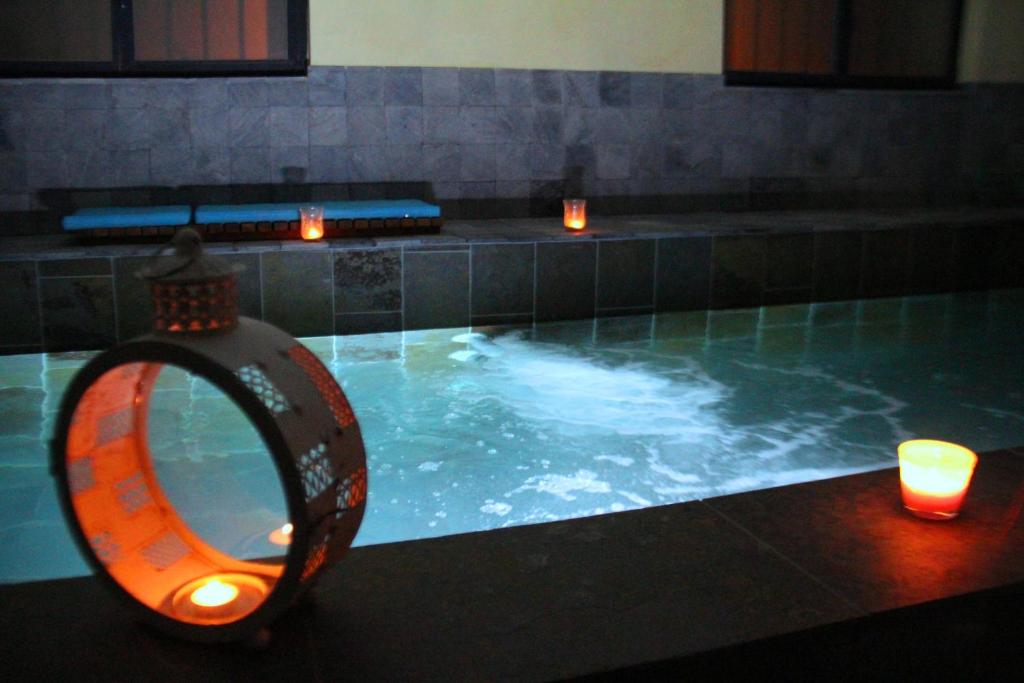 蓬格拉纳达蓝旅馆的一个带两个蜡烛和镜子的游泳池