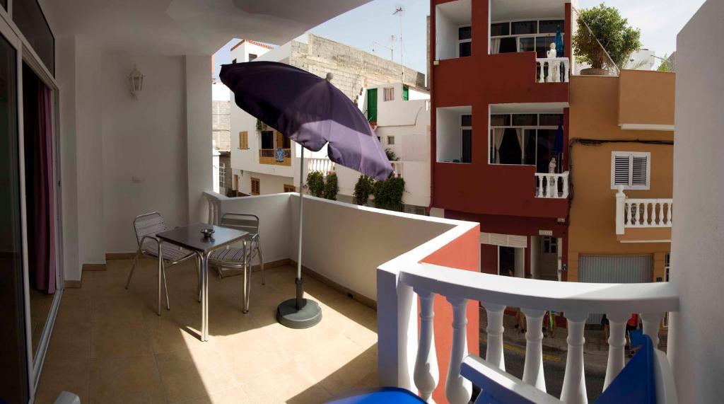 阿尔卡拉Casa Atlantica的阳台配有桌子和雨伞。