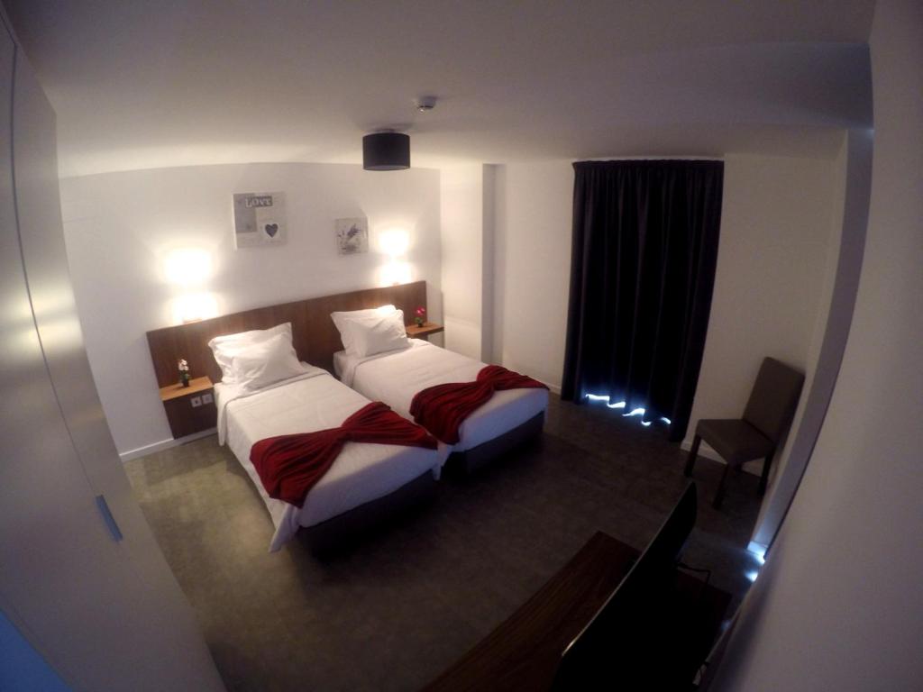 圣克鲁斯Albergaria O Professor的酒店客房设有两张床和窗户。