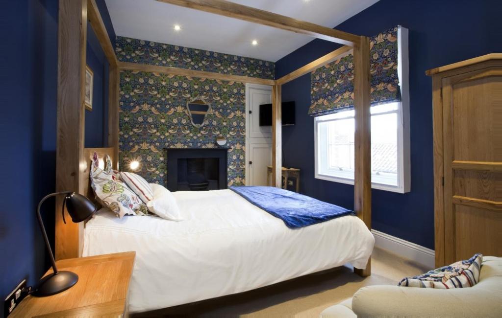 约克The Kings Apartment的蓝色卧室设有一张床和一个壁炉