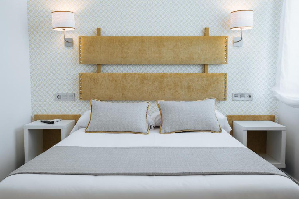 坎加斯-德奥尼斯圣克鲁斯酒店的一间卧室配有一张带2个床头柜的大型白色床