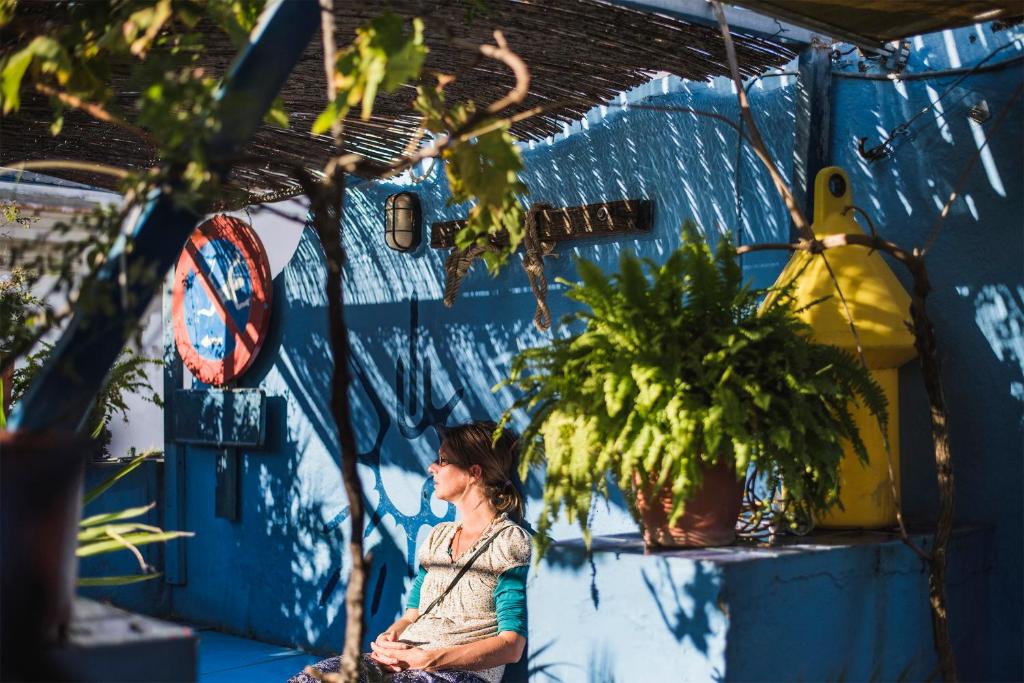加的斯卡萨卡拉科尔旅舍的坐在蓝墙前的有植物的女人