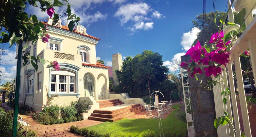 蒙得维的亚Alquimista Montevideo的院子里的白色大房子,鲜花盛开