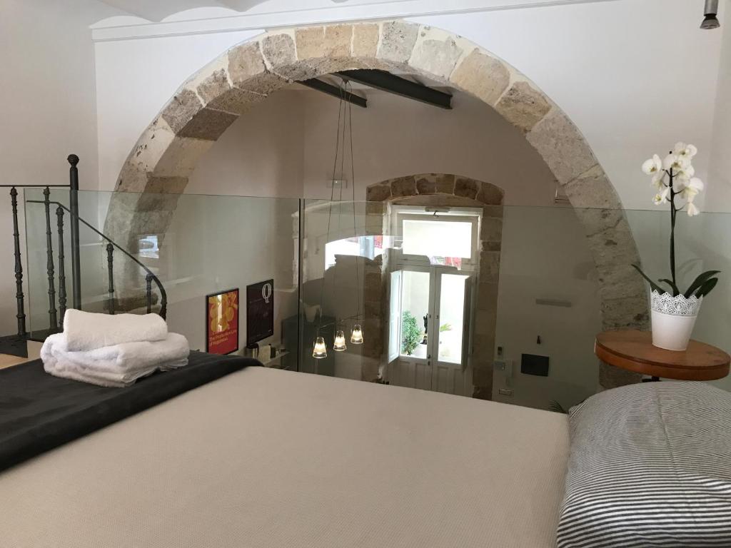 锡拉库扎卡西纳特伦托度假屋的一间设有床铺和石拱门的房间