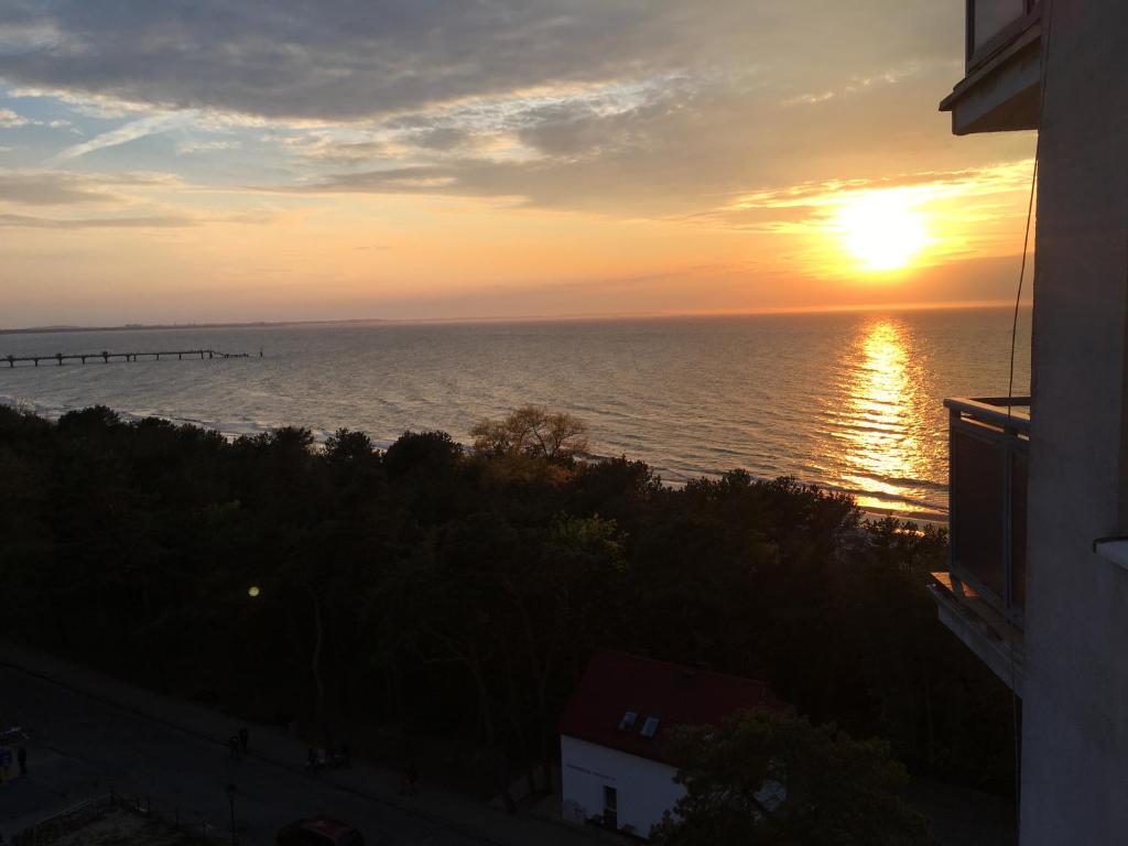 米兹多洛杰Wolin-Travel Campingowa z widokiem na morze的日落时分从大楼欣赏海景