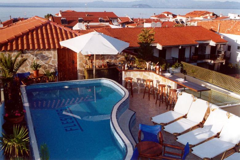 佩科霍里Hotel Flesvos的一座房子里一个带椅子和遮阳伞的游泳池