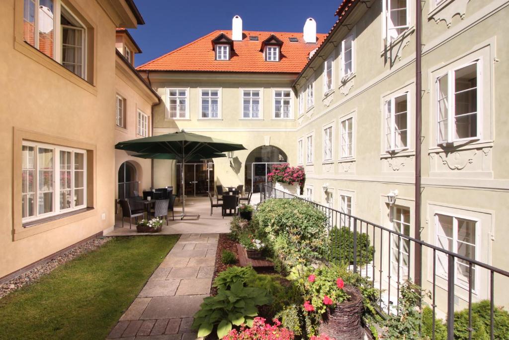 布拉格阿皮亚酒店的一座带雨伞和鲜花的建筑的庭院