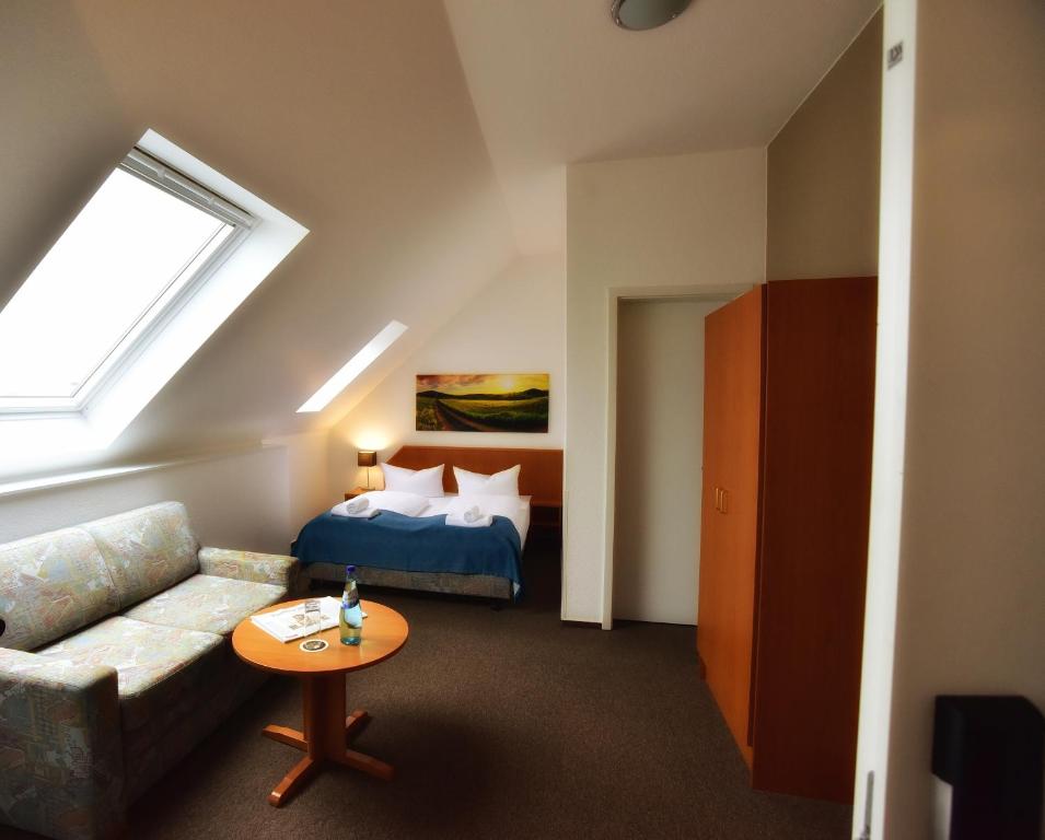 美因河畔法兰克福Goethe Hotel Messe by Trip Inn的一间配有沙发、一张床和窗户的客房