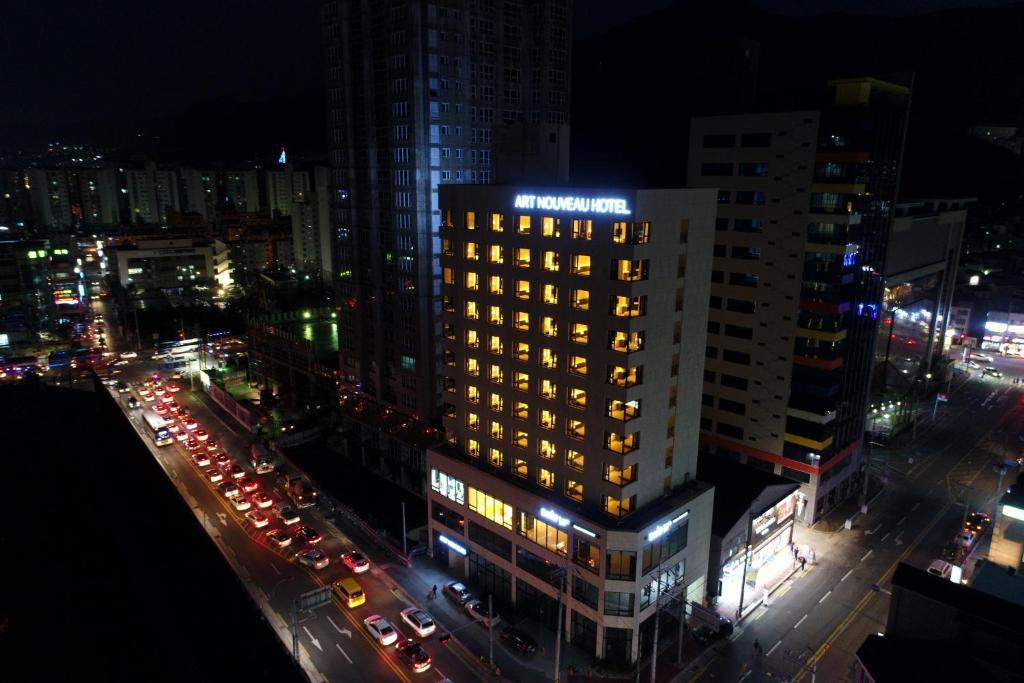 巨济巨济新艺术套房酒店的城市的一座有灯光的建筑