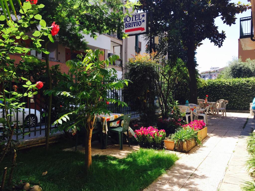 米兰布里维奥酒店的花园配有桌椅和鲜花