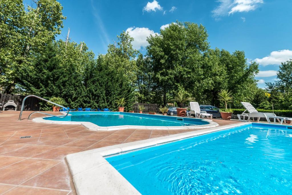 希欧福克佩特尔公寓式酒店的度假村的游泳池,带椅子和树木