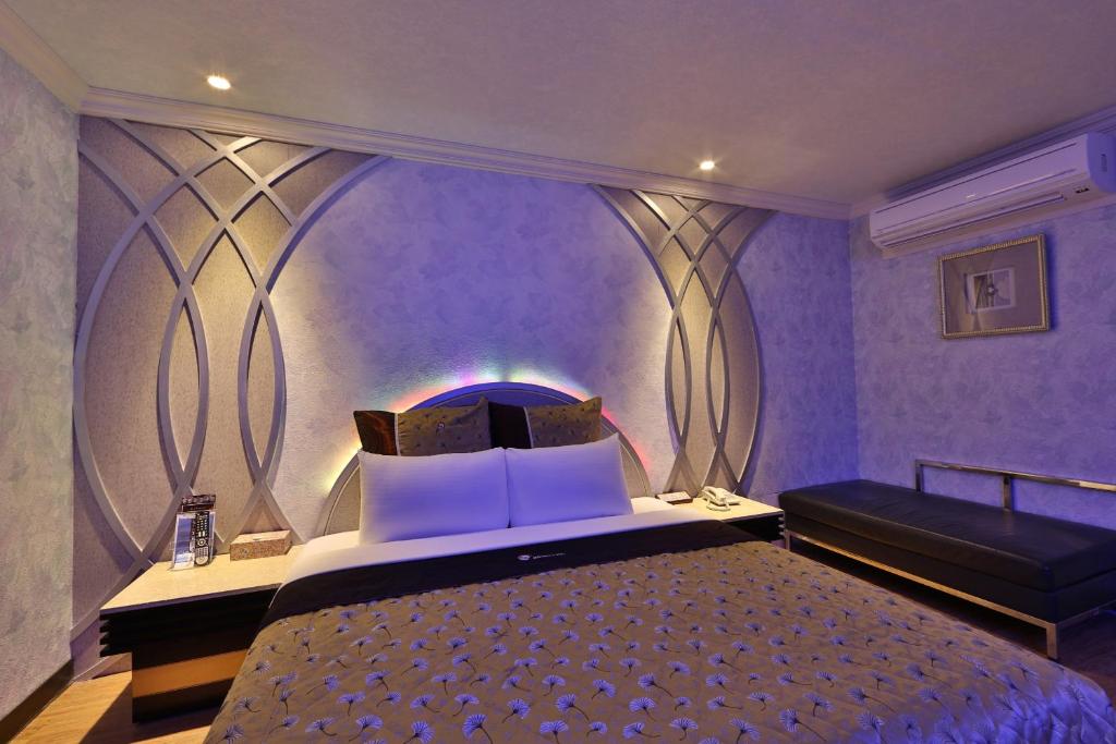 树林区月圆汽车旅馆的紫色卧室配有一张床和一张沙发