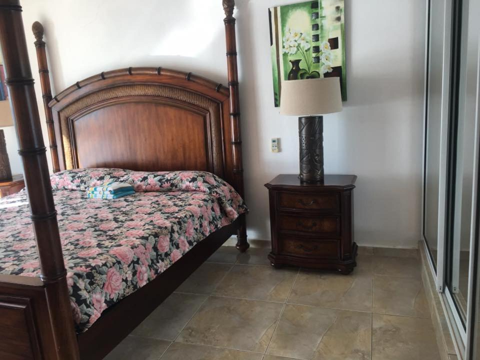 阿瓜达哥伦布酒店的一间卧室配有一张床和一张带台灯的桌子
