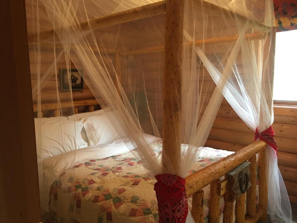 Bridge LakeMontana Hill Guest Ranch的一间卧室配有带蚊帐的天蓬床。