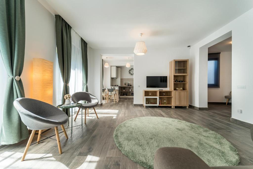 布加勒斯特Vila Cotroceni Boutique Apartments的客厅配有两把椅子和绿色地毯