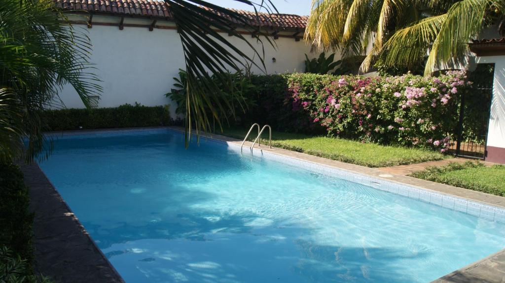 莱昂Hotel Cacique Adiact的庭院里的一个蓝色海水游泳池