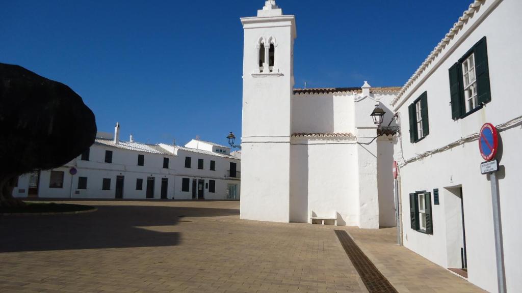 福尔内利斯ESGLESIA 4 by SOM Menorca的一座白色的大建筑,设有钟楼