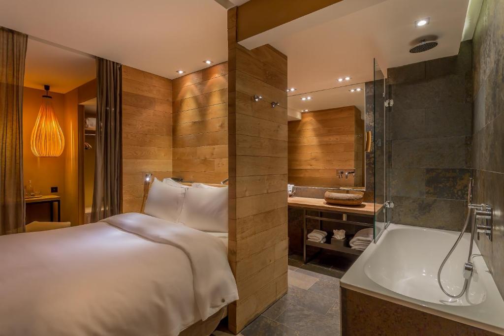 巴黎喜登酒店的酒店客房配有一张床和浴缸。