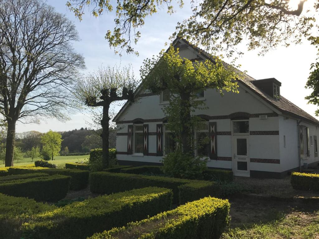 赫鲁斯贝克B&B Het Rijkzicht的前面有树 ⁇ 的白色房子