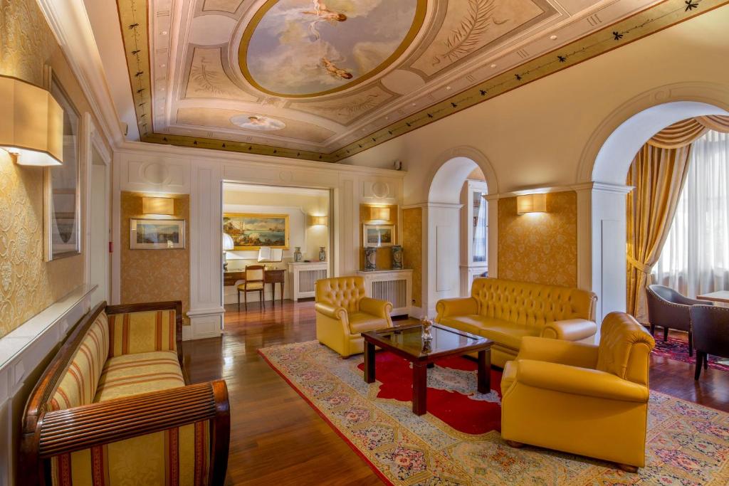 罗马拉瑞泽顿扎酒店的客厅设有黄色家具和格子天花板