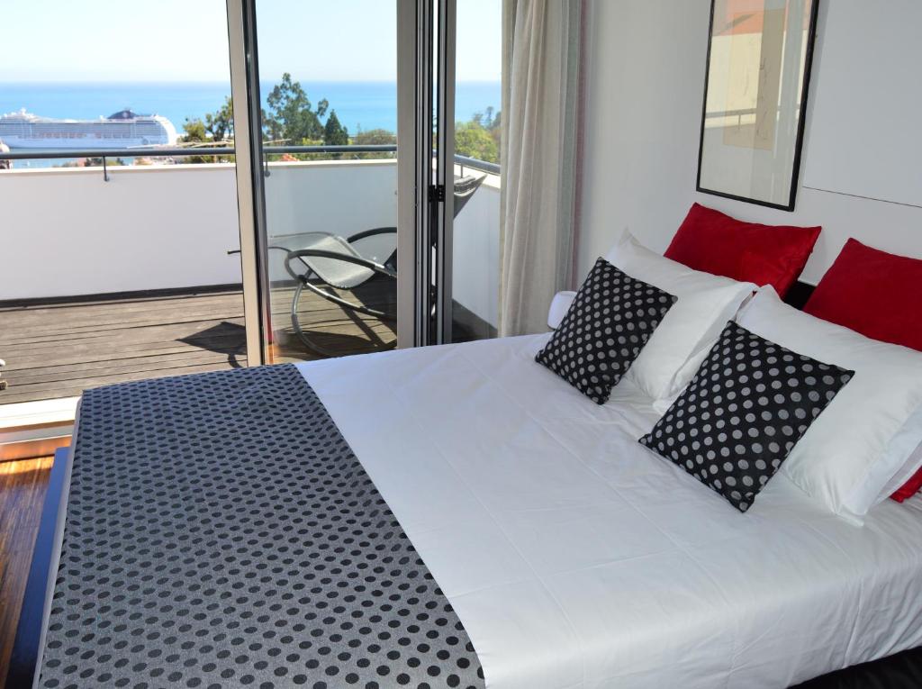 丰沙尔vista dos arrifes的一间卧室配有一张带黑白枕头的床