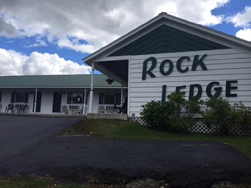 亚历山德里亚贝Rock Ledge Motel的白色的建筑,上面有摇滚的词