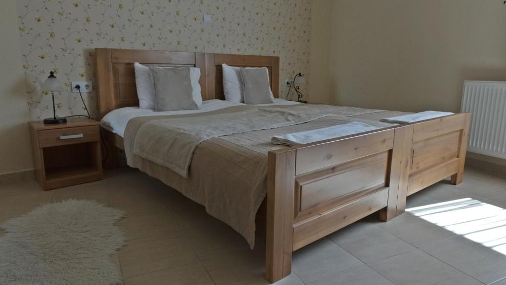 考洛乔Alice Panzió Gold的一间卧室配有一张大床和木制梳妆台