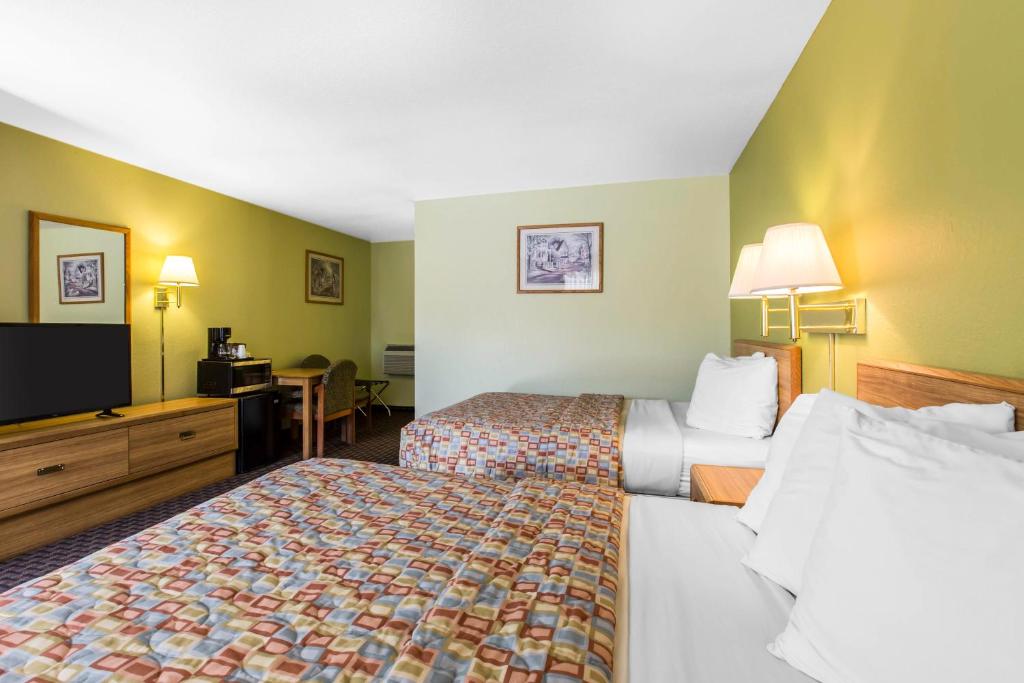 甘尼森Rodeway Inn Gunnison的酒店客房设有两张床和一台平面电视。