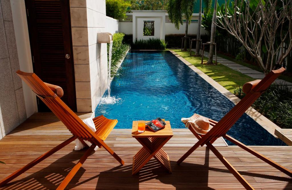邦涛海滩Two Villas HOLIDAY - Oxygen Style Bang Tao Beach的游泳池畔的两把椅子和一张桌子