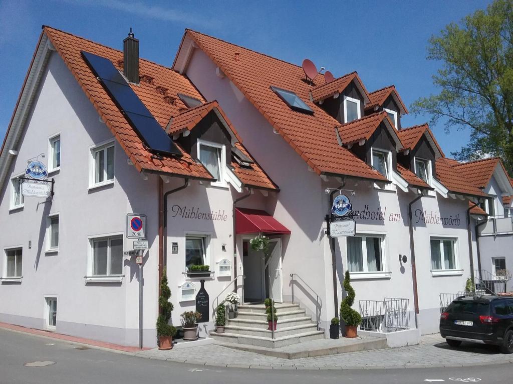 陶贝尔比绍夫斯海姆Landhotel Garni am Mühlenwörth的一座白色的大建筑,有红色的屋顶