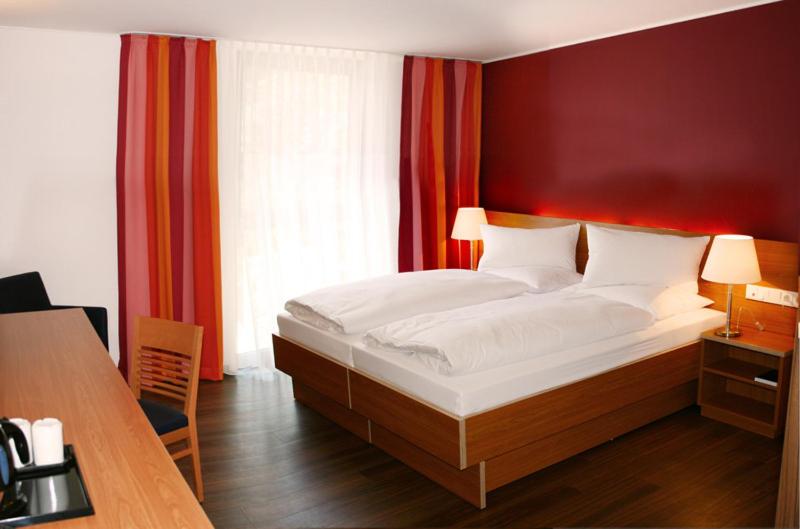 埃森弗朗茨酒店的一间卧室设有一张带红色墙壁的大床