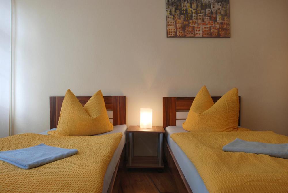 波茨坦波茨坦老城酒店的一间卧室配有两张带黄床单和灯的床