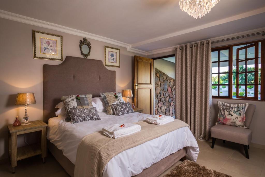 比勒陀利亚La Vida Luka - Luxury Guesthouse的一间卧室配有一张大床和毛巾