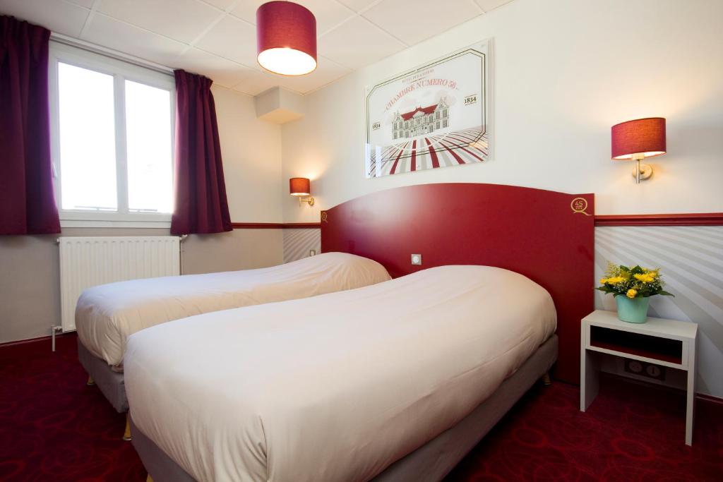 波尔多DES四姐妹酒店的酒店客房设有两张床和窗户。