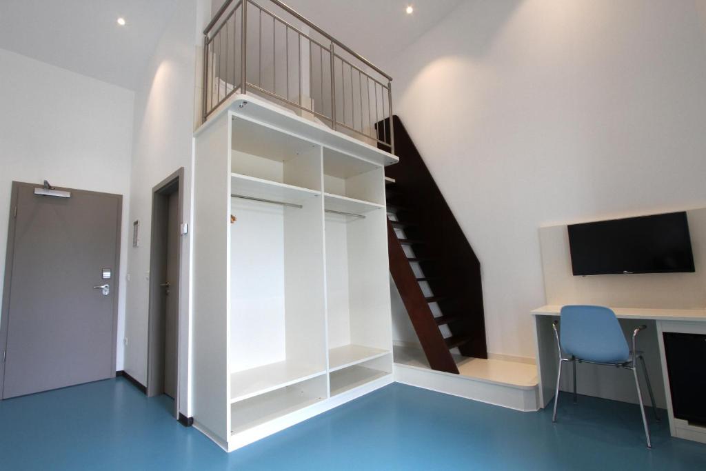 PlankstadtNeumann's Übernachten的一间设有楼梯和白色墙壁的客房