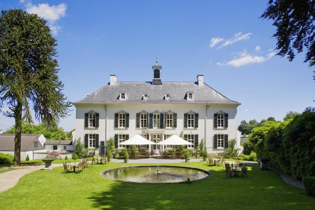 瓦尔斯彼尔德伯格酒店的一座大型白色房子,在院子里设有一个池塘