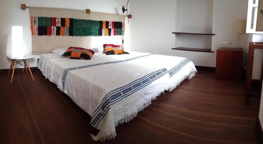 明德卢Casa Café Mindelo的一间卧室设有一张大床,铺有木地板