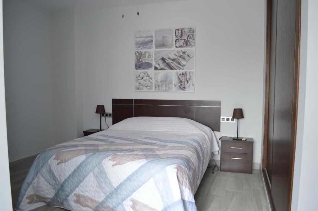 阿达莱斯Apartamento Prado - Casa Eva的一间卧室配有一张床和一个带两盏灯的床头柜。