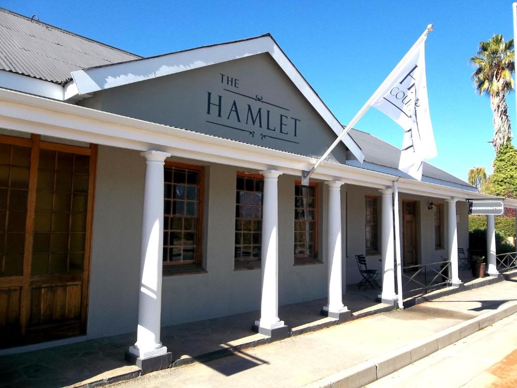 塞雷斯The Hamlet Country Lodge的前面有两面旗帜的建筑